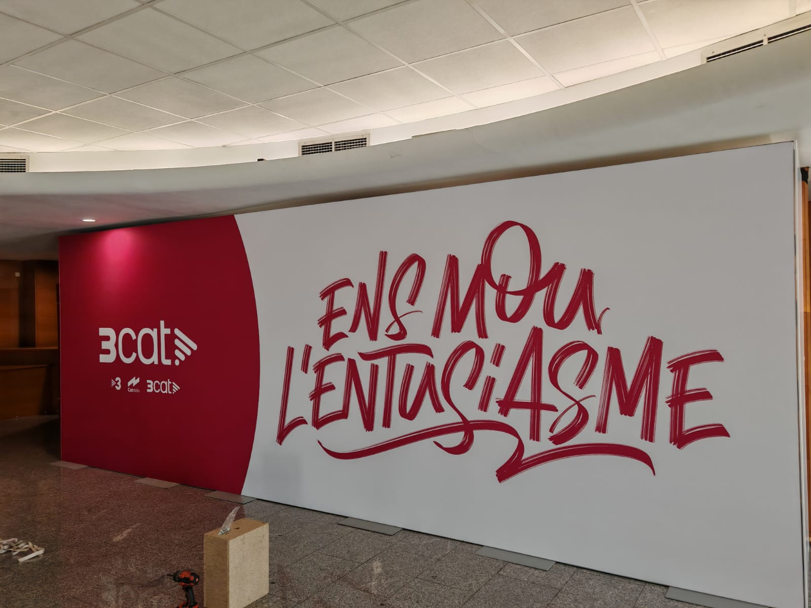 Vista general del mural corporativo 3cat con lettering de gran formato en rojo y blanco