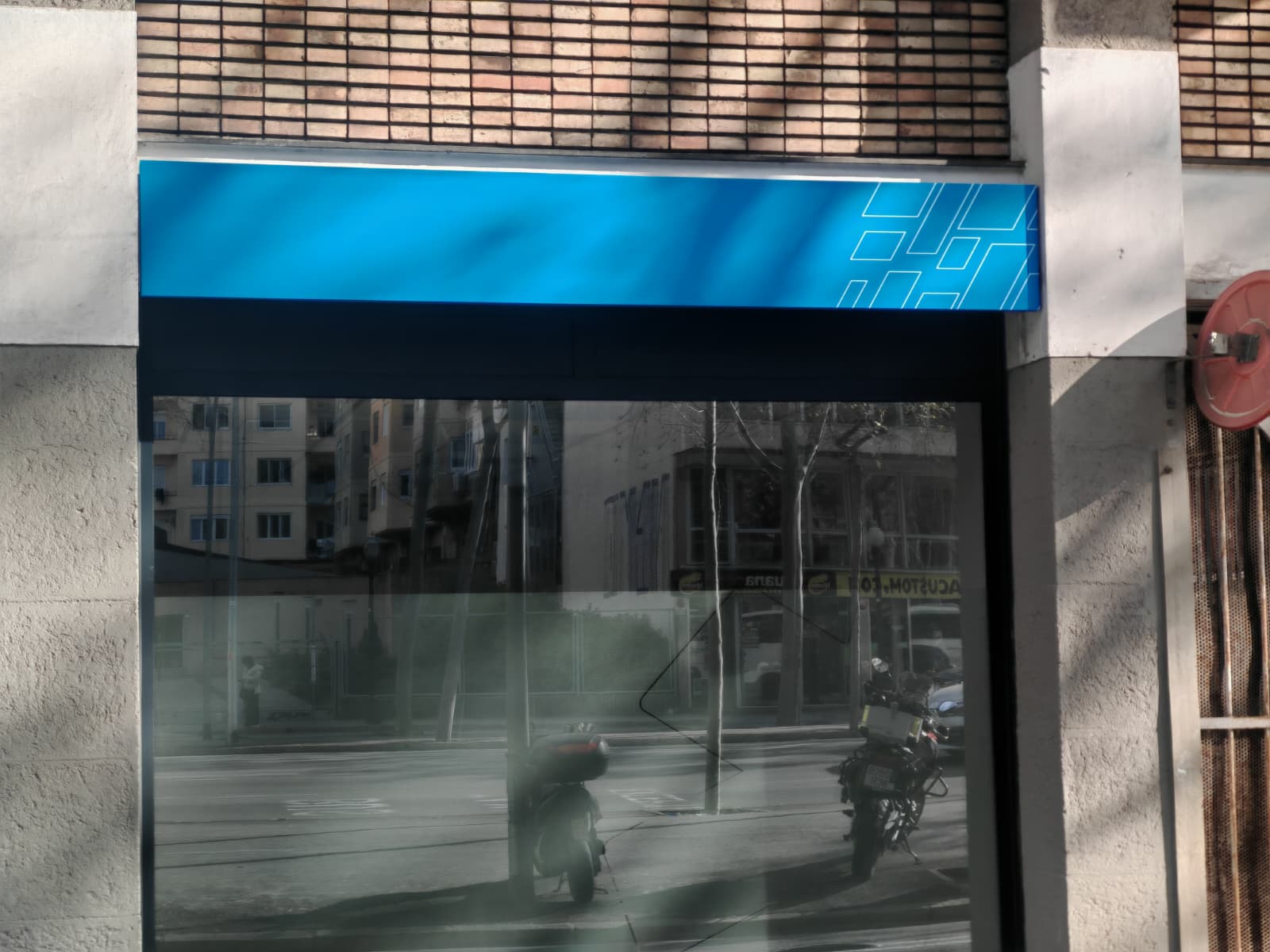 Detalle lateral de la marquesina con patrón geométrico corporativo Ambulàncies Tomàs