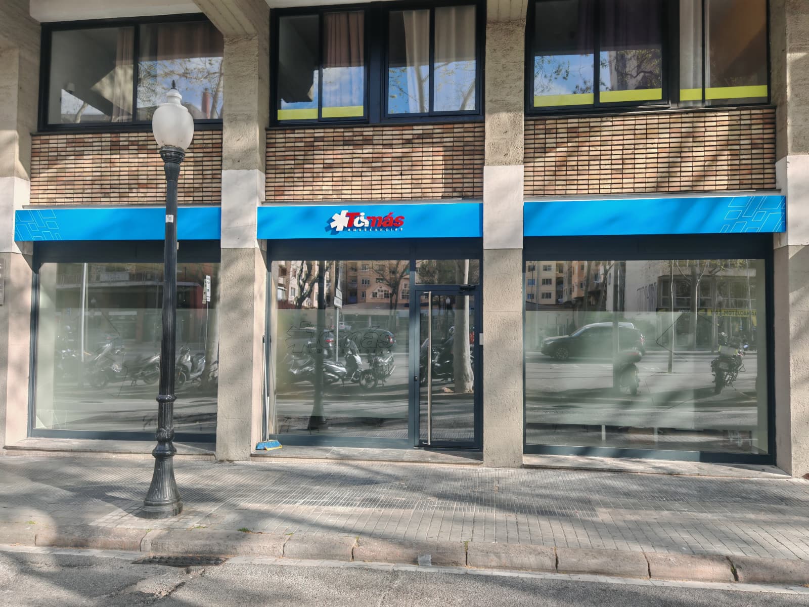Vista de calle del local Ambulàncies Tomàs con rotulación de fachada en azul corporativo