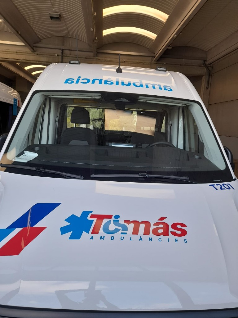 Detalle frontal de ambulancia Ambulàncies Tomàs con logotipo y rotulación sanitaria