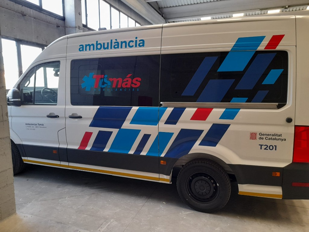 Lateral de ambulancia rotulada con gráfica geométrica azul para flota sanitaria