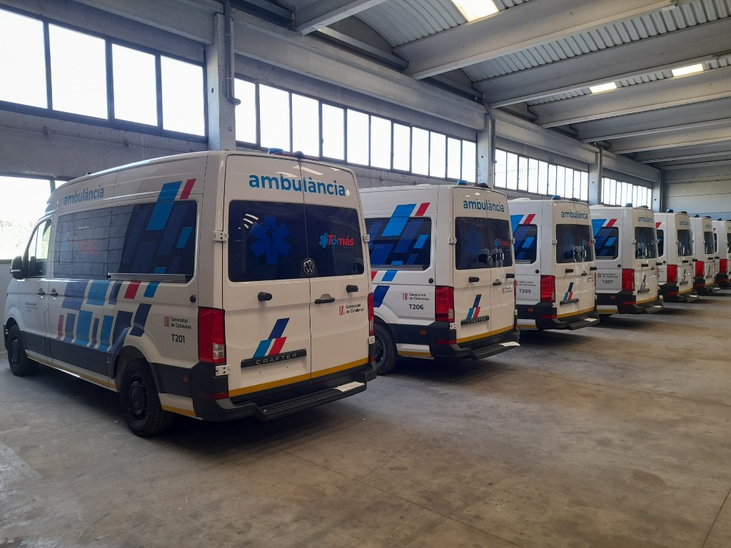 Conjunto de ambulancias rotuladas en línea dentro de nave logística