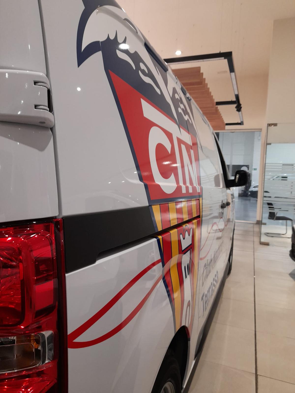 Vista trasera lateral de furgoneta CTN con escudo y ondas rojas corporativas