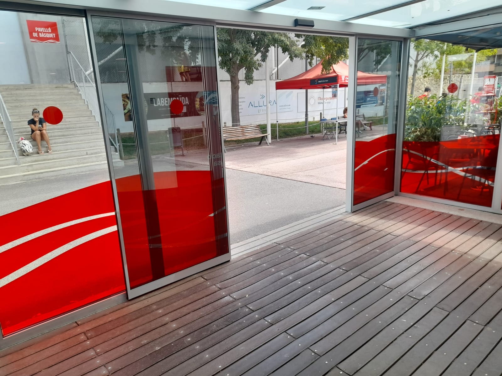 Vista exterior de las cristaleras del Club Natació Terrassa con vinilo rojo corporativo