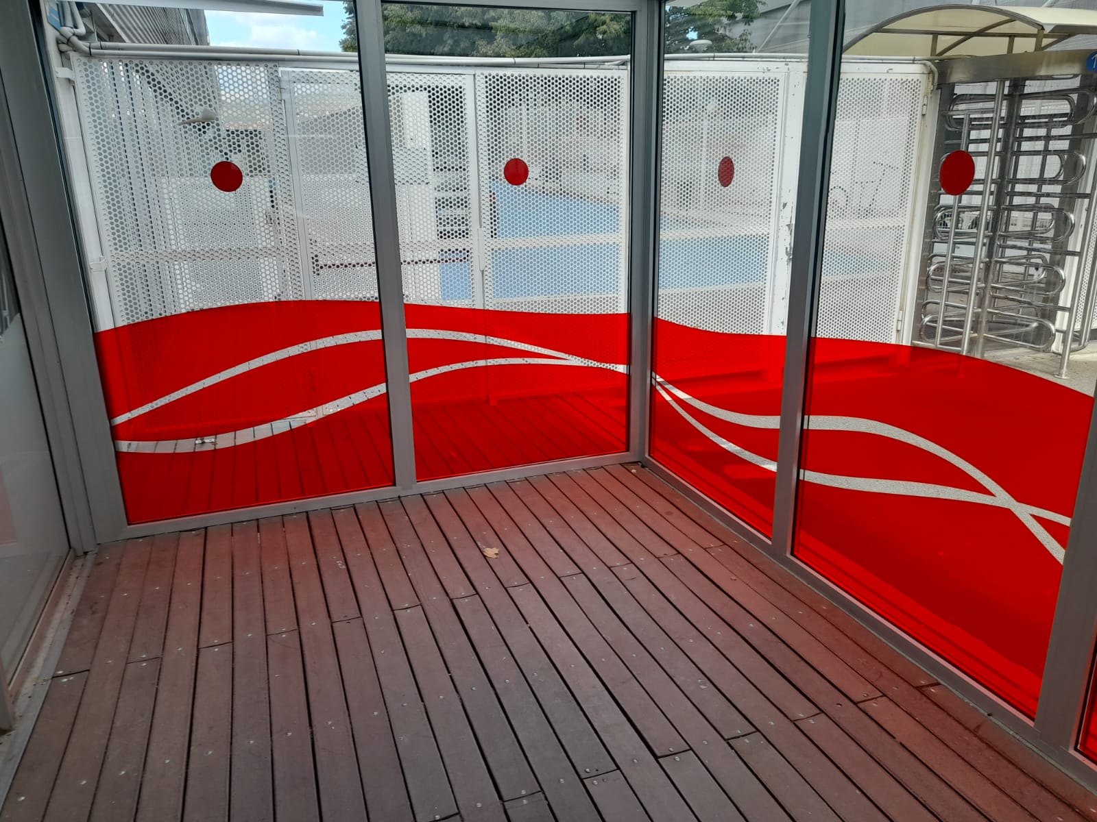 Vista interior del hall de acceso CTN con vinilado de cristaleras en rojo y blanco