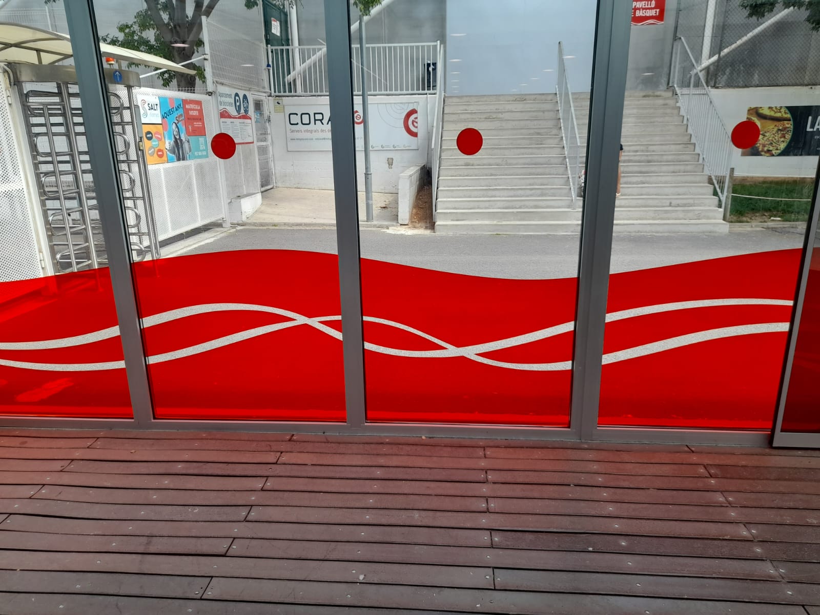 Vista exterior completa de la fachada acristalada del Club Natació Terrassa con patrón de ondas