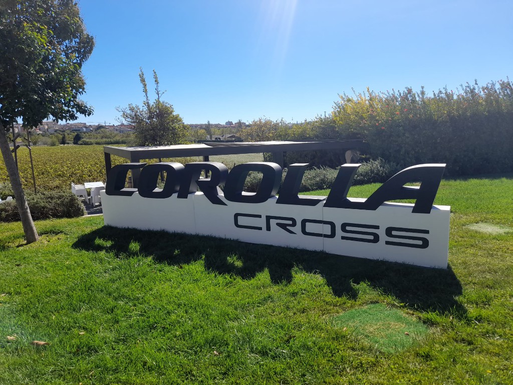 Vista frontal de letras Corolla Cross en activación de marca al aire libre