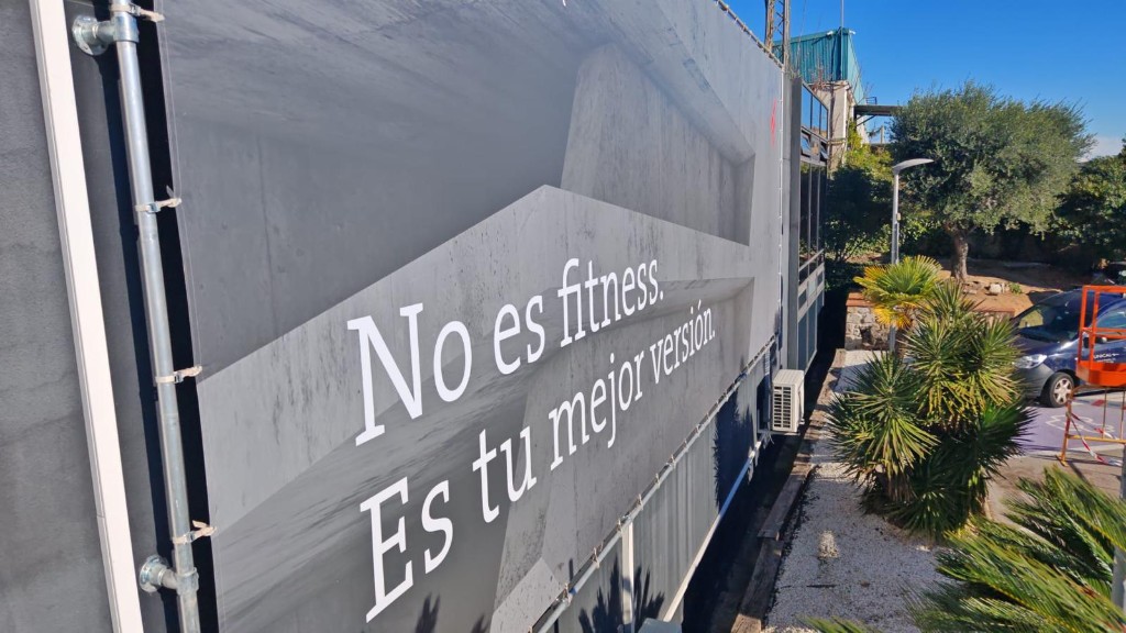 Lona de gran formato Fibra Max con claim motivacional en lateral de fachada