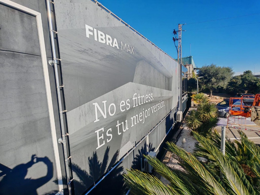 Detalle frontal de lona Fibra Max con diseño minimalista sobre fachada exterior