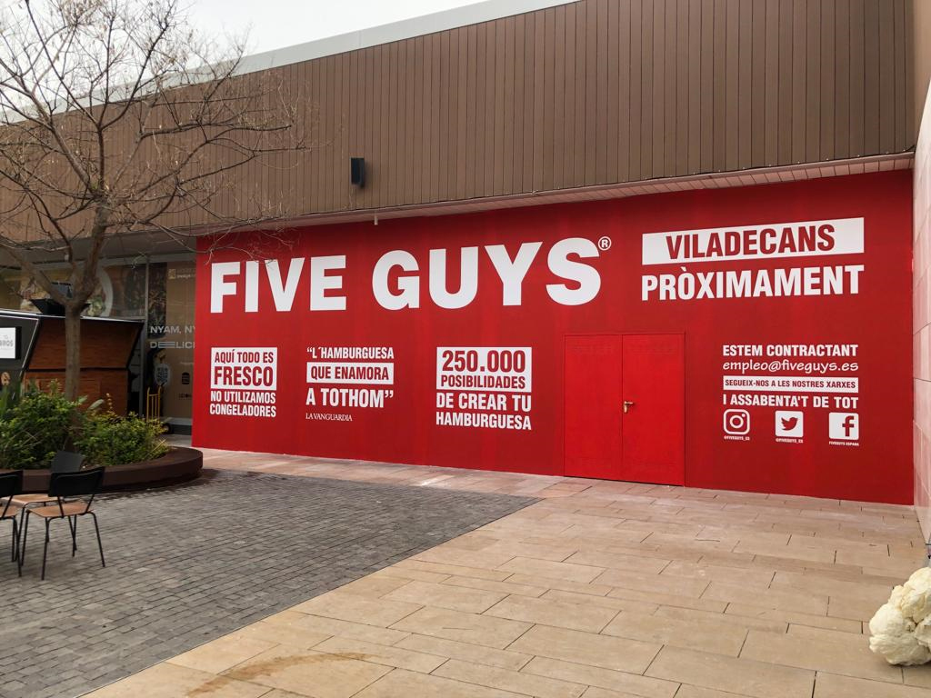 Cerramiento publicitario Five Guys Viladecans con vinilo rojo corporativo producido por Unical Graphic