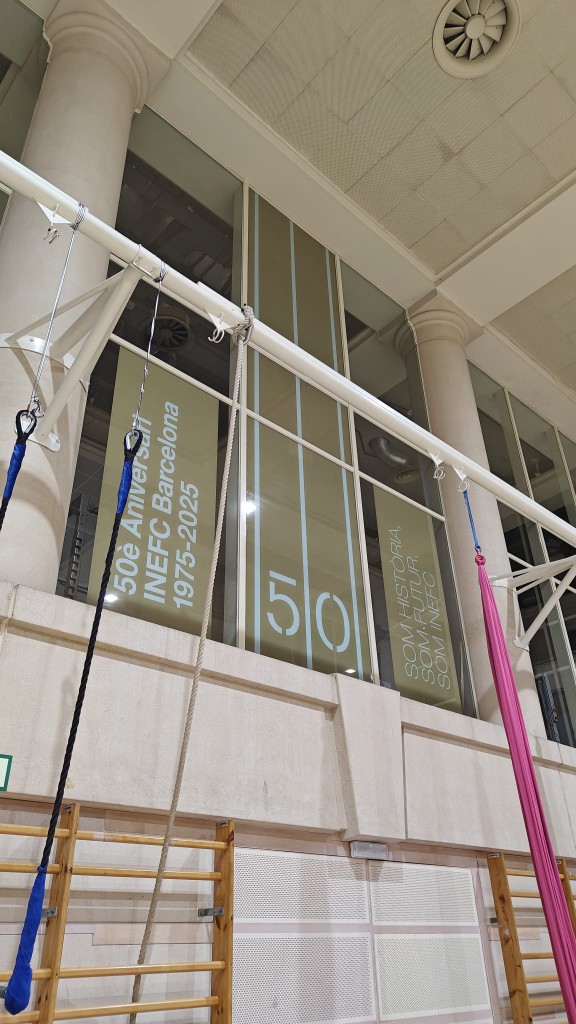 Detalle de lonas verticales interiores con identidad INEFC Barcelona 50 años