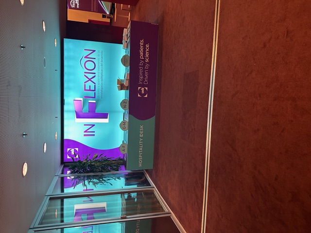 Mostrador de hospitalidad INFLEXION UCB con señalética de acceso y branding corporativo