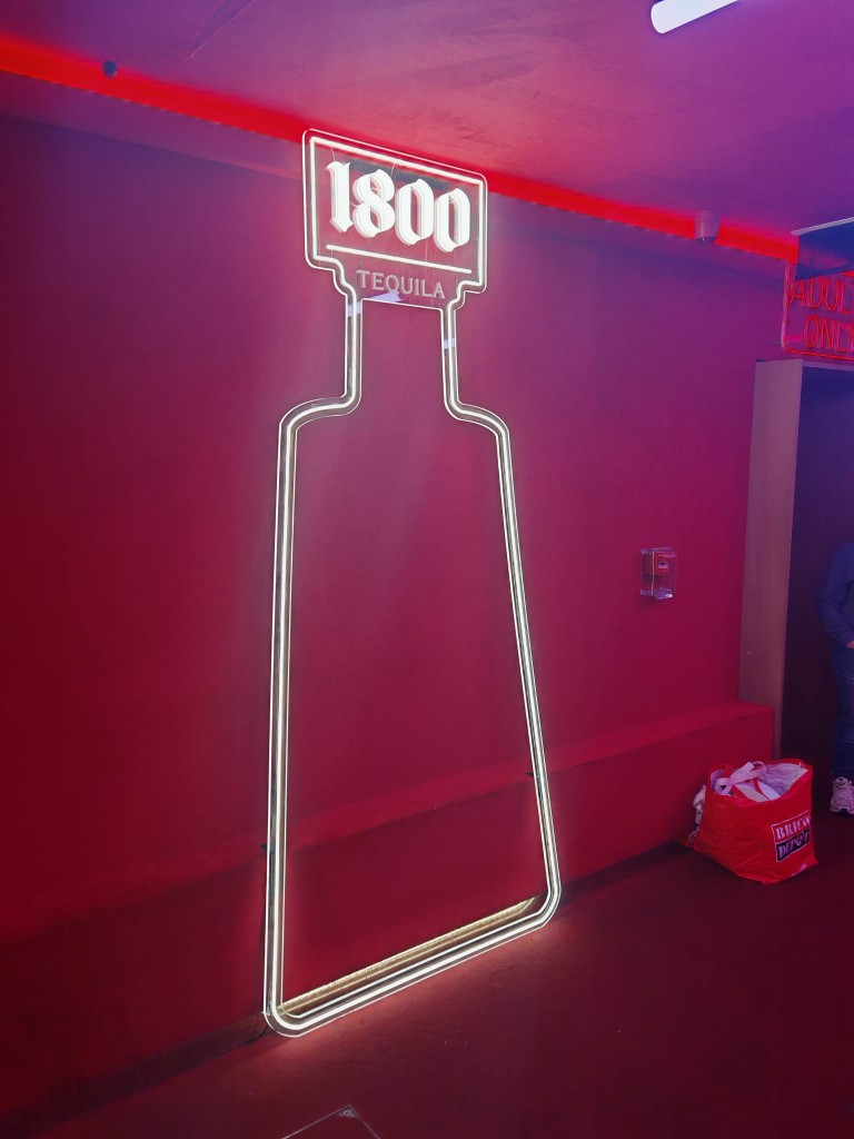 Silueta de botella 1800 Tequila retroiluminada en ambiente rojo nocturno