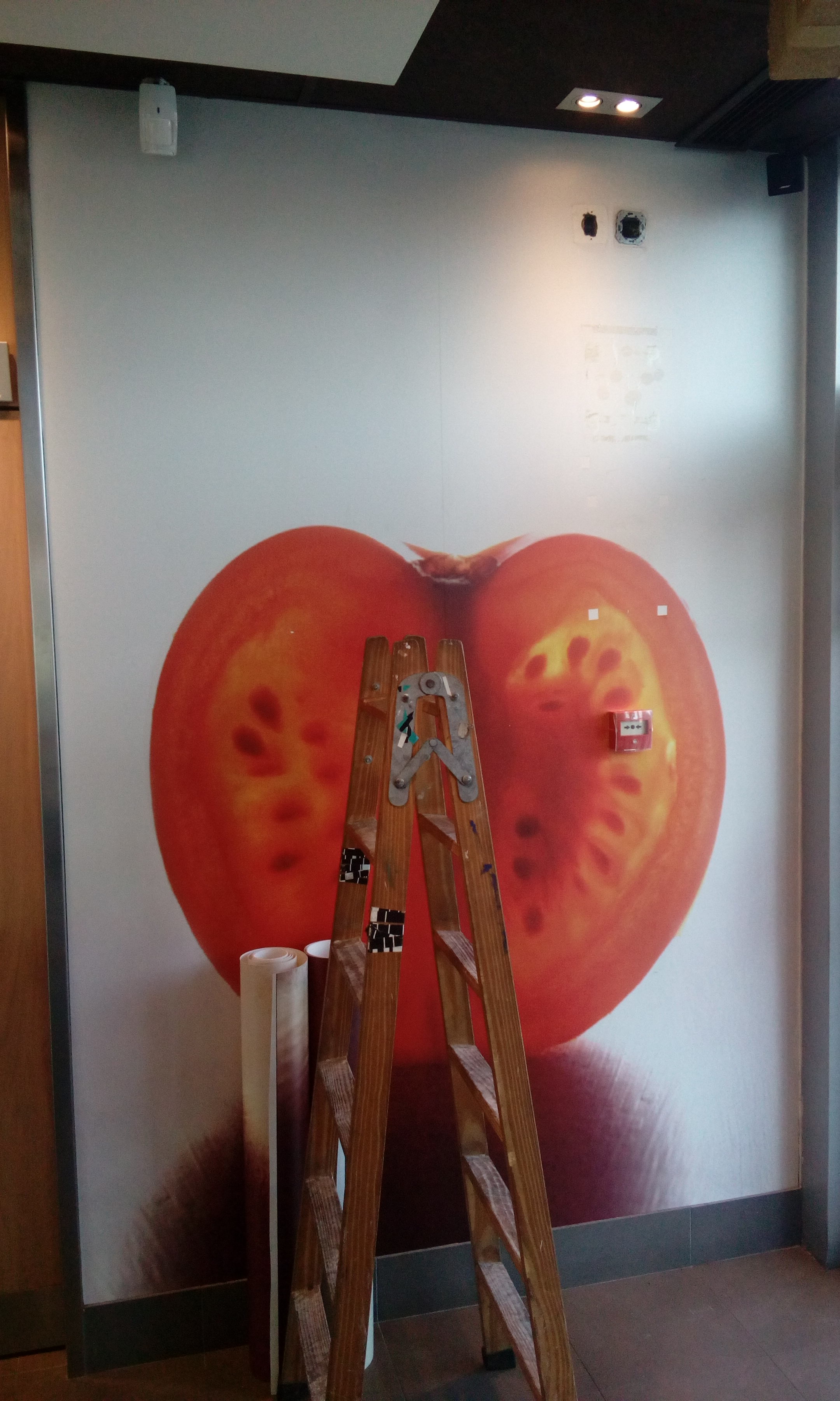 Instalación de mural fotográfico de tomates en restaurante McDonald's