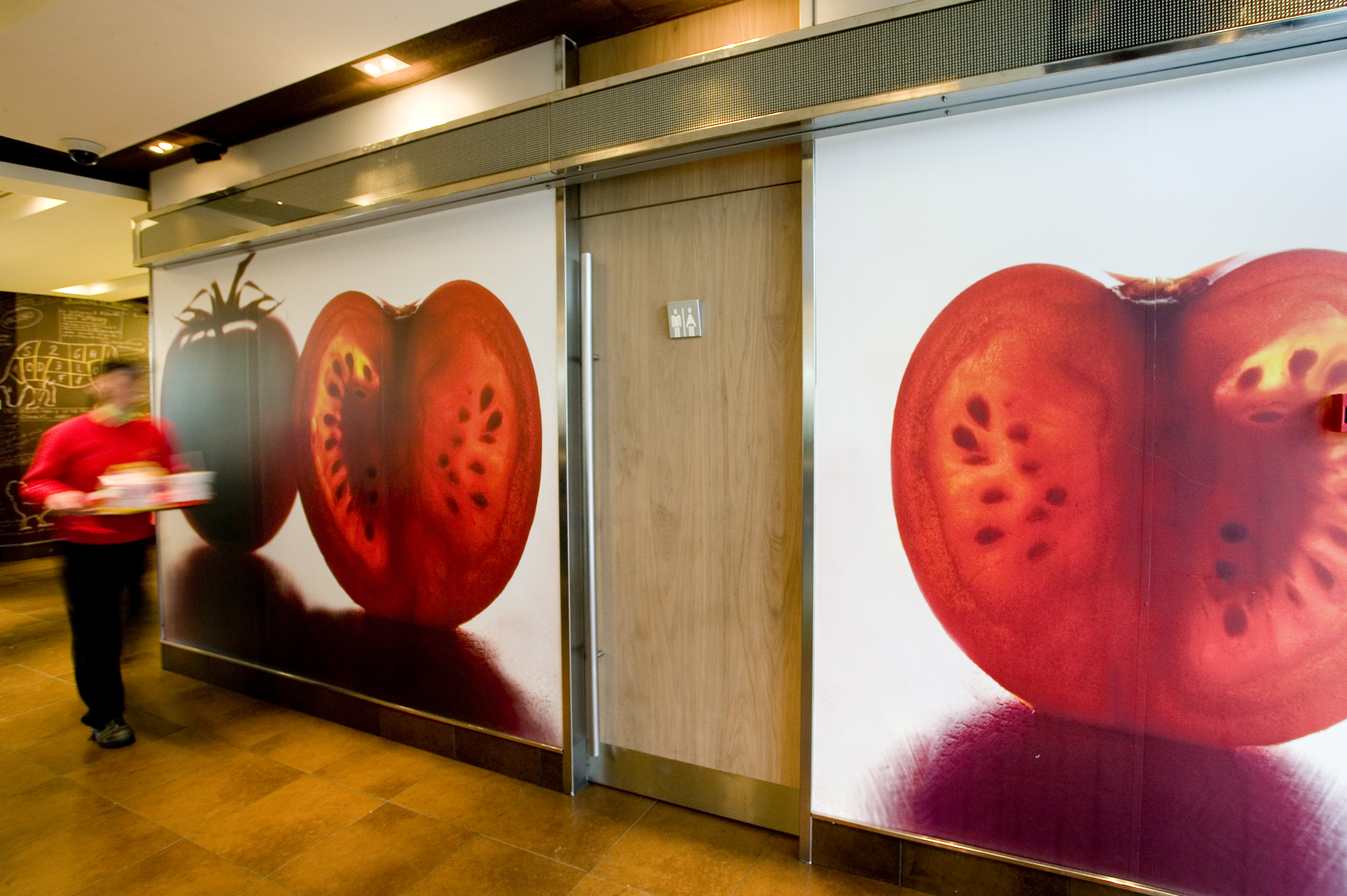 Mural fotográfico de tomates instalado en la pared de un restaurante McDonald's, producido por Unical Graphic Barcelona
