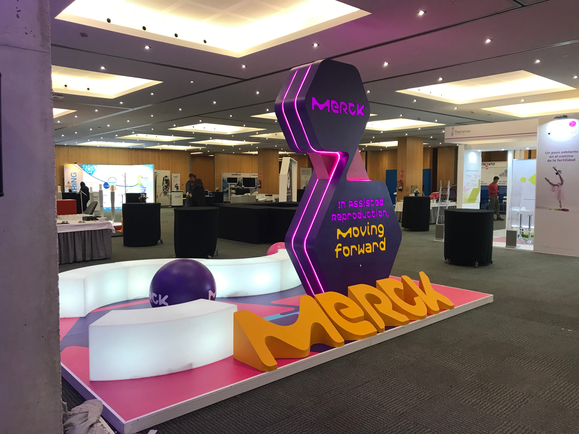 Estructura Merck vista frontal con letras 3D y LED neón magenta