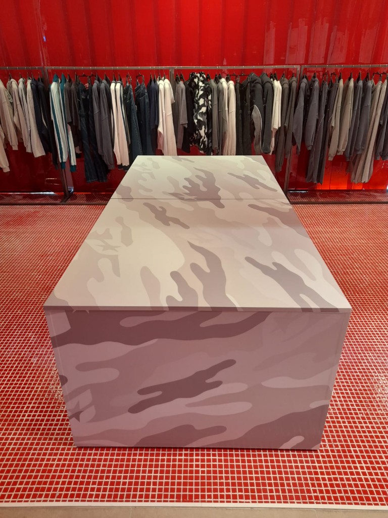 Vista frontal de mesa expositiva vinilada en zona central de tienda Cold Culture