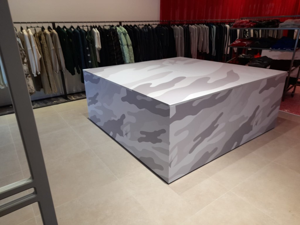 Mesa de exposición Cold Culture con acabado gráfico envolvente en tonos neutros