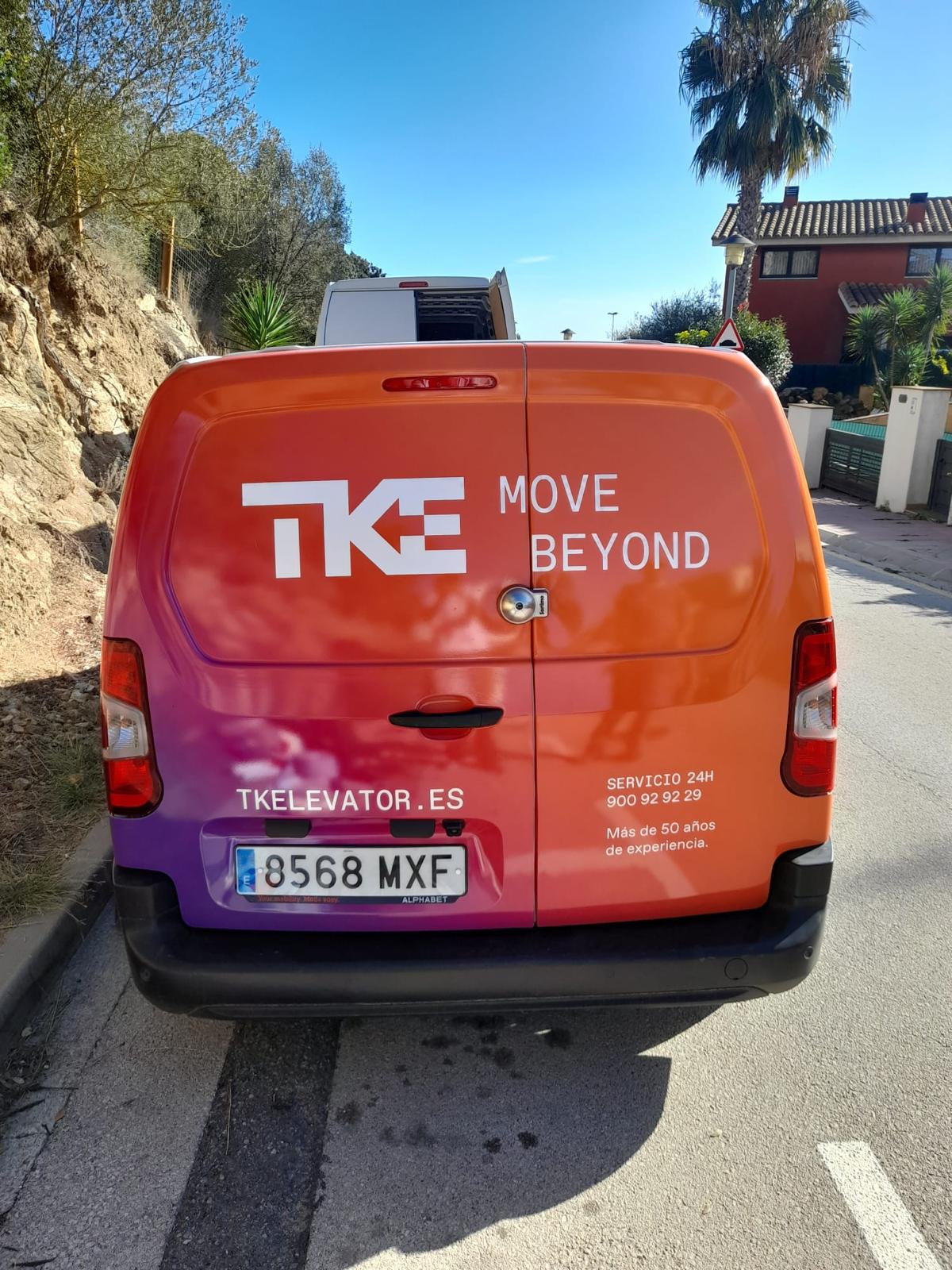 Parte trasera de furgoneta TKE TK Elevator con wrapping en degradado naranja morado y claim Move Beyond
