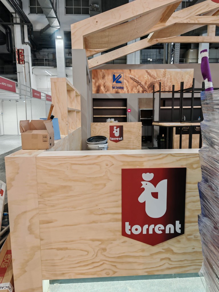 Mostrador y zona de trabajo del stand Torrent con rotulación corporativa