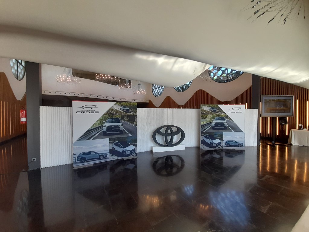 Vista general de escenario interior Toyota Cross con paneles gráficos y logotipo central