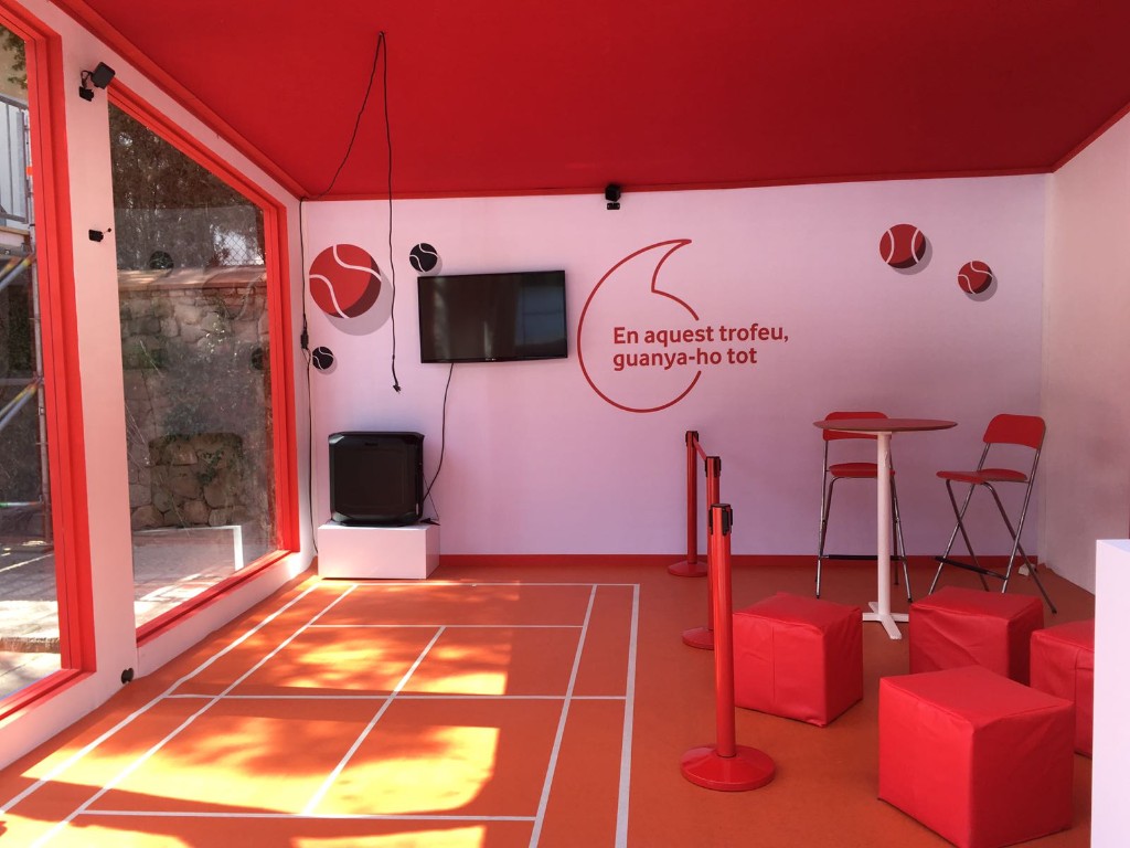 Interior de espacio Vodafone con gráfica corporativa y zona de interacción