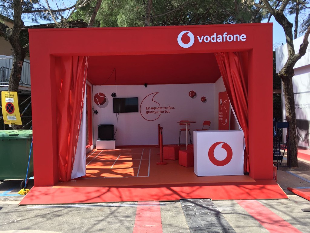 Espacio pop-up de Vodafone en evento con estructura roja y branding integral